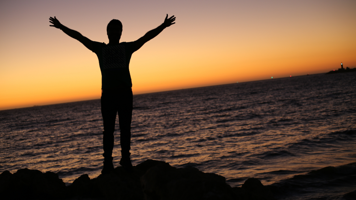 person worshipping God near the ocean